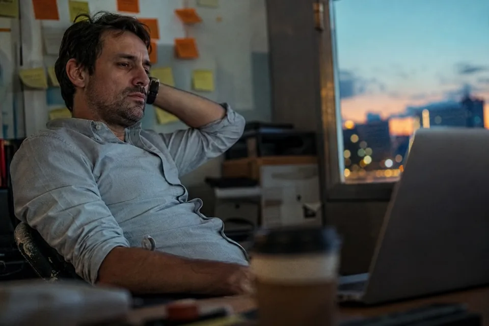 Founder at a desk late in the day checking recovered subscription revenue