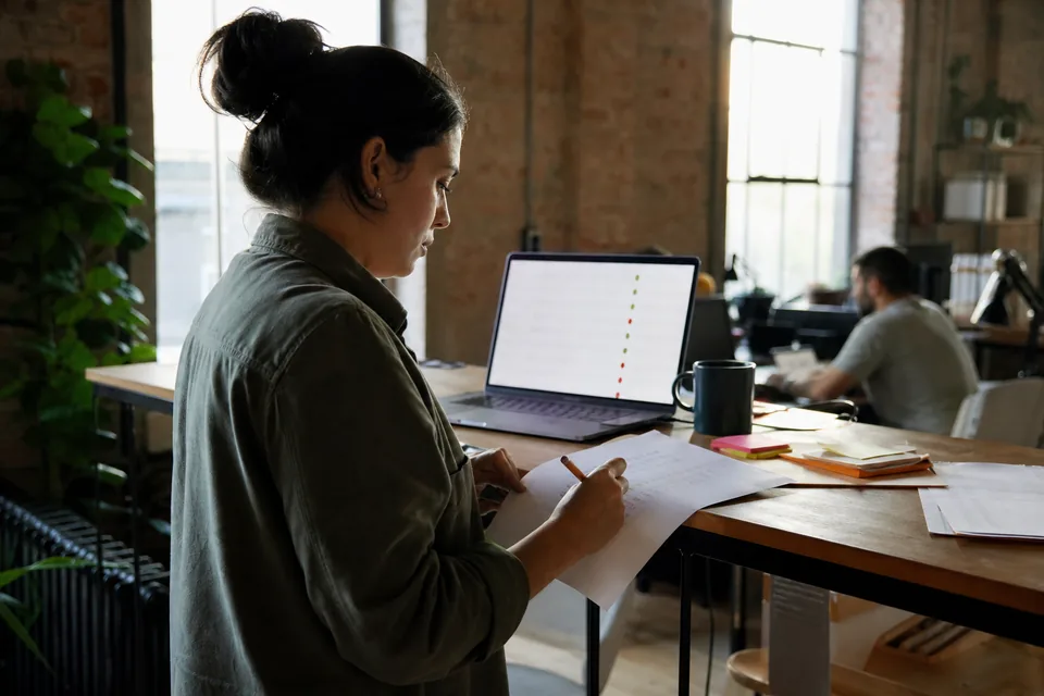 Operations lead at a standing desk working through a list of declined subscription renewals